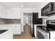Bright kitchen featuring white cabinets, stainless steel appliances, and hardwood flooring at 7192 Catalina St, Spring Hill, FL 34606