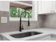 Stylish kitchen with a dark sink, quartz countertops, a modern pull down faucet, and a backyard view at 7192 Catalina St, Spring Hill, FL 34606