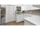 A modern kitchen area showcasing white cabinets, countertops, and fixtures with a view to the backyard at 7192 Catalina St, Spring Hill, FL 34606