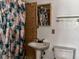 Bathroom featuring a pedestal sink, decorative tile, and a toilet with a colorful shower curtain at 723 W Bayshore Dr, Tarpon Springs, FL 34689