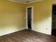 Bedroom featuring wood laminate floors, neutral walls, and an interior door to another room at 723 W Bayshore Dr, Tarpon Springs, FL 34689