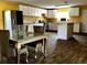 Open kitchen with a dining area, featuring white cabinets, new appliances, and dark floors at 723 W Bayshore Dr, Tarpon Springs, FL 34689