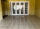 Spacious living room with tile flooring, yellow walls and white French doors to another room at 723 W Bayshore Dr, Tarpon Springs, FL 34689