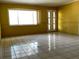 Bright living room featuring large window, tile flooring, and a white front door at 723 W Bayshore Dr, Tarpon Springs, FL 34689