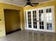Spacious living room with tile flooring, yellow walls and white French doors at 723 W Bayshore Dr, Tarpon Springs, FL 34689