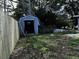 Wooden shed with an open door in the backyard and a new wooden fence on the side at 723 W Bayshore Dr, Tarpon Springs, FL 34689