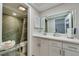 Well-lit bathroom with white vanity, sink, mirror, and adjacent shower showcasing a clean and functional design at 7412 Bellows Falls Ln, Hudson, FL 34667