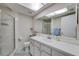 Bright bathroom featuring a shower, vanity, and skylight at 7412 Bellows Falls Ln, Hudson, FL 34667