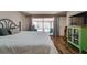 Bright bedroom featuring wood flooring, neutral walls, large sliding glass doors, and stylish furnishings and decor at 7412 Bellows Falls Ln, Hudson, FL 34667