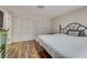 Cozy bedroom showcasing hardwood floors, a large closet, a comfy bed, and subtle decor for relaxation at 7412 Bellows Falls Ln, Hudson, FL 34667