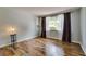 Bedroom with wood floors, curtains, and a large window at 7412 Bellows Falls Ln, Hudson, FL 34667