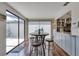 Bright dining area with wood floors, a modern table with stools, and sliding glass doors to the patio at 7412 Bellows Falls Ln, Hudson, FL 34667