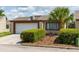 Cozy home featuring an attached garage, well-maintained landscaping, and a beautiful palm tree accenting the front yard at 7412 Bellows Falls Ln, Hudson, FL 34667