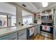 Bright kitchen with stainless steel appliances, light countertops, and direct view to patio at 7412 Bellows Falls Ln, Hudson, FL 34667