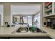 Galley kitchen with stainless steel sink and view to dining area and outdoor patio at 7412 Bellows Falls Ln, Hudson, FL 34667