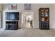Living room with neutral carpet, a view into another room, and a wall-mounted television at 7412 Bellows Falls Ln, Hudson, FL 34667