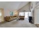 Open concept living room featuring vaulted ceilings, neutral carpet, and a sliding glass door at 7412 Bellows Falls Ln, Hudson, FL 34667