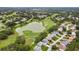 Scenic aerial view of a golf course community with lush greenery, a pond, and well-maintained homes at 7423 Woodhollow Rd, Spring Hill, FL 34606