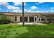 A charming back patio on a lush lawn has sliding glass doors and windows that brighten the interior space at 7423 Woodhollow Rd, Spring Hill, FL 34606