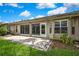 The home features a charming, open back patio with sliding glass doors leading into the home and manicured lawn at 7423 Woodhollow Rd, Spring Hill, FL 34606
