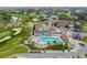 Overhead shot of the community pool and lounge area, surrounded by palm trees and golf cart parking at 7423 Woodhollow Rd, Spring Hill, FL 34606
