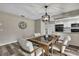 Dining area with modern light fixture, hardwood floors, and a view into the kitchen for seamless entertaining at 7423 Woodhollow Rd, Spring Hill, FL 34606