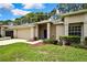 Charming single-story home featuring a blue front door, attached garage, and well-maintained landscaping at 7423 Woodhollow Rd, Spring Hill, FL 34606