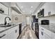 Open kitchen featuring white cabinets, granite counters, and modern stainless steel appliances at 7423 Woodhollow Rd, Spring Hill, FL 34606