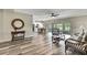 Open-concept living room boasts stylish wood floors, natural light, and seamless flow to dining and kitchen areas at 7423 Woodhollow Rd, Spring Hill, FL 34606