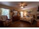 Charming bedroom with wood floors, ceiling fan, colorful accents, and two large windows at 7550 Jomel Dr, Weeki Wachee, FL 34607
