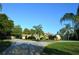Well-manicured lawn with a circular driveway that approaches a charming one story home and garage at 7550 Jomel Dr, Weeki Wachee, FL 34607