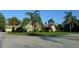 Lush lawn and circular driveway leading to a one story house, accented by several palm trees at 7550 Jomel Dr, Weeki Wachee, FL 34607