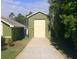 Detached garage with a large door and a private driveway on a sunny day at 7550 Jomel Dr, Weeki Wachee, FL 34607