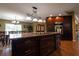 Spacious kitchen island with granite countertops, dark wood cabinets, and a pendant light fixture at 7550 Jomel Dr, Weeki Wachee, FL 34607