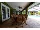 Covered lanai featuring an outdoor dining area with a large wooden table and chairs at 7550 Jomel Dr, Weeki Wachee, FL 34607