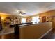 Split-level living room with wood flooring, a ceiling fan, and a half-wall divider at 7550 Jomel Dr, Weeki Wachee, FL 34607