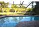 The screened-in pool is surrounded by lush landscaping and offers ample privacy at 7550 Jomel Dr, Weeki Wachee, FL 34607
