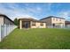 This backyard features lush green grass, white vinyl fencing, and a screened-in porch at 758 Alpine Thistle Dr, Brooksville, FL 34604