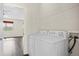 Well-lit laundry room featuring modern appliances, a wire shelf, and an open doorway at 758 Alpine Thistle Dr, Brooksville, FL 34604