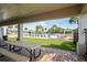 View of the community pool area with outdoor seating, surrounded by green landscaping and palm trees at 758 Alpine Thistle Dr, Brooksville, FL 34604
