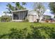 Backyard shows the patio, yard with green grass, landscaping, and hot tub area at 7701 Anaheim Ave, New Port Richey, FL 34655