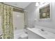Clean bathroom with a shower/tub, white tile, sink, and mirror at 7701 Anaheim Ave, New Port Richey, FL 34655