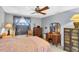 Comfortable bedroom showcasing fan, patterned bedding, and warm furnishings at 7701 Anaheim Ave, New Port Richey, FL 34655