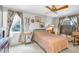 Cozy bedroom with ceiling fan, patterned bedding, and floral curtains at 7701 Anaheim Ave, New Port Richey, FL 34655