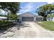 Lovely home with a brick facade and an inviting driveway, surrounded by lush greenery at 7701 Anaheim Ave, New Port Richey, FL 34655