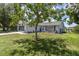 Charming single-story home with a well-manicured lawn and mature shade tree in the front yard at 7701 Anaheim Ave, New Port Richey, FL 34655