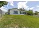 Exterior view of the side and back of the home from the green lawn at 7701 Anaheim Ave, New Port Richey, FL 34655