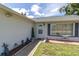 Charming front porch with a decorative door, side table, and a manicured garden at 7701 Anaheim Ave, New Port Richey, FL 34655