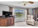 Comfortable living area with a view of the scenic lake, television and tiled floors at 7701 Anaheim Ave, New Port Richey, FL 34655