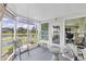 Enclosed patio boasts peaceful lake views, a table and a chair to relax and unwind at 7701 Anaheim Ave, New Port Richey, FL 34655